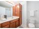 Bathroom featuring a vanity with wooden cabinets, toilet, and towel rack at 15554 Stronvar House Ln, Charlotte, NC 28277