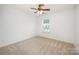 Neutral bedroom with large window, ceiling fan, and plush carpet at 15554 Stronvar House Ln, Charlotte, NC 28277