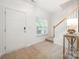 Bright entryway with neutral carpet, white door, and visible staircase at 15554 Stronvar House Ln, Charlotte, NC 28277