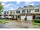 Well-manicured townhomes featuring garages, landscaping, and sidewalks create a welcoming neighborhood setting at 15554 Stronvar House Ln, Charlotte, NC 28277