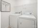 Convenient laundry room features a washer, dryer, and ample shelving for storage solutions at 15554 Stronvar House Ln, Charlotte, NC 28277