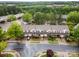Aerial view of townhomes with garages, neat landscaping, and a car parked out front, creating a welcoming neighborhood scene at 15554 Stronvar House Ln, Charlotte, NC 28277