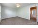 Spacious carpeted bedroom with a ceiling fan and a view to an open doorway at 15623 Sir Charles Pl, Charlotte, NC 28277