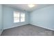 The bedroom features light blue walls, gray carpet, and a double window at 15623 Sir Charles Pl, Charlotte, NC 28277