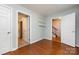 Cozy bedroom with hardwood floors, three doors, and convenient built-in shelving at 15623 Sir Charles Pl, Charlotte, NC 28277