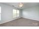 A bedroom with a ceiling fan, large windows, and neutral carpeting at 15623 Sir Charles Pl, Charlotte, NC 28277