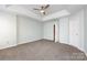 Bedroom featuring neutral walls, a tray ceiling with fan, and doorway to hall at 15623 Sir Charles Pl, Charlotte, NC 28277