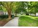 Landscaped community walking path with bench seating and mature trees at 15623 Sir Charles Pl, Charlotte, NC 28277