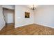 View of the dining room with wood flooring and chandelier with kitchen access at 15623 Sir Charles Pl, Charlotte, NC 28277
