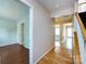 A bright hallway with hardwood floors connecting multiple rooms and a staircase at 15623 Sir Charles Pl, Charlotte, NC 28277