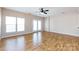 Open living room featuring wood floors, a ceiling fan, and double doors to the outside at 15623 Sir Charles Pl, Charlotte, NC 28277
