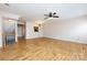 A modern living room features wood floors, a ceiling fan, and staircase at 15623 Sir Charles Pl, Charlotte, NC 28277
