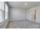 Bright, carpeted bedroom featuring a large window and neutral walls at 16042 River Tree Ln, Charlotte, NC 28278