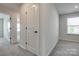 Carpeted hallway featuring doors and a bedroom with a window at 16042 River Tree Ln, Charlotte, NC 28278