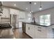 Open concept kitchen featuring white cabinets, stainless steel appliances, an island, and hardwood floors at 16042 River Tree Ln, Charlotte, NC 28278