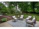Inviting backyard patio with stylish outdoor seating and a view of the expansive, tree-filled backyard and small storage shed at 1610 Ford St, Charlotte, NC 28216