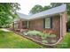 Charming brick home with a cozy front porch swing and colorful flower bed in a well-manicured front yard at 1610 Ford St, Charlotte, NC 28216