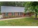 Traditional brick home boasts a large lawn, neatly landscaped garden, and charming front porch at 1610 Ford St, Charlotte, NC 28216