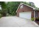 Spacious garage and concrete driveway, complemented by the home's brick exterior and fenced backyard with storage shed at 1610 Ford St, Charlotte, NC 28216