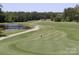 Scenic view of a well-maintained golf course with lush green fairways, a pond, and mature trees at 1610 Ford St, Charlotte, NC 28216