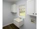 Functional laundry room with a utility sink, built-in cabinets, and a window overlooking the serene backyard at 1610 Ford St, Charlotte, NC 28216