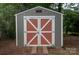 Charming storage shed with double doors, offering ample storage space in the large, tree-filled backyard of the home at 1610 Ford St, Charlotte, NC 28216