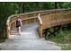 Scenic walking trail featuring a Personal walking over a wooden bridge surrounded by lush greenery and trees at 1610 Ford St, Charlotte, NC 28216