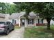 Charming single-story home with mature landscaping, a brick foundation, and a gray SUV in the driveway at 1623 Flagler Ln, Charlotte, NC 28216