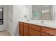 Bathroom vanity features wood-grain cabinets, double sinks, mirror, and decorative lighting at 16615 Crimson Sargent Dr, Charlotte, NC 28213