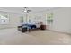 Bright bedroom with three windows, neutral carpet, ceiling fan, bed, and decorative wall art at 16615 Crimson Sargent Dr, Charlotte, NC 28213