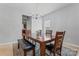 Bright dining room features modern chandelier, window, and wooden table with chairs and bench at 16615 Crimson Sargent Dr, Charlotte, NC 28213