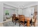 Open concept dining room features chandelier, grey rug, view to entry and living room with grey furniture at 16615 Crimson Sargent Dr, Charlotte, NC 28213