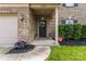 Inviting front entrance with a black door, brick facade, manicured landscaping, and a two car garage at 16615 Crimson Sargent Dr, Charlotte, NC 28213