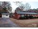 Brick home featuring a detached garage with a driveway and a neatly maintained lawn at 1708 Dogwood Ln, Lancaster, SC 29720