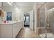 Well-lit bathroom with double vanity, a glass-enclosed shower, and tile flooring at 1825 Lotus Ln, Denver, NC 28037