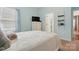Comfortable bedroom featuring a bed with soft throw blanket, dresser with TV, and light blue walls at 1825 Lotus Ln, Denver, NC 28037