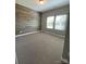 Spacious bedroom showcasing wood accent wall, plush carpet, and ample natural light at 1825 Lotus Ln, Denver, NC 28037
