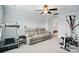 Spacious bonus room with a comfortable couch, ceiling fan, and workout equipment for relaxation and fitness at 1825 Lotus Ln, Denver, NC 28037