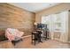 Inviting home office with a wood accent wall, comfortable chair, and functional desk setup at 1825 Lotus Ln, Denver, NC 28037