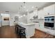 Bright, modern kitchen features an island with bar seating, stainless steel appliances, and white cabinetry at 1825 Lotus Ln, Denver, NC 28037
