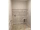 Tiled laundry room showcasing wire shelving, tile floors, and utility connections at 1825 Lotus Ln, Denver, NC 28037
