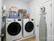 Well-lit laundry room featuring a modern washer and dryer set with storage shelves and ironing board at 1825 Lotus Ln, Denver, NC 28037
