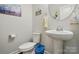 Stylish powder room featuring a modern pedestal sink, toilet, and tasteful decor for guests' convenience at 1825 Lotus Ln, Denver, NC 28037