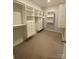 Bright walk-in closet with ample storage space, shelving, and neutral carpeting at 1825 Lotus Ln, Denver, NC 28037