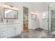 Bright bathroom featuring dual vanities, ample lighting, modern finishes, and a glass shower at 1830 Wickford Pl, Charlotte, NC 28203
