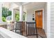 Inviting covered porch with rocking chairs, wood flooring, and a stylish front door at 1830 Wickford Pl, Charlotte, NC 28203