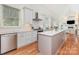 Spacious kitchen with an island, stainless steel appliances, white cabinets, and hardwood flooring at 1830 Wickford Pl, Charlotte, NC 28203