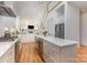 Open-concept kitchen with stainless steel appliances, island, white cabinets, and hardwood floors at 1830 Wickford Pl, Charlotte, NC 28203