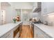 Galley kitchen featuring stainless steel appliances, white cabinets, quartz counters, and hardwood floors at 1830 Wickford Pl, Charlotte, NC 28203