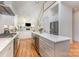 Open-concept kitchen with stainless steel appliances, island, white cabinets, and hardwood floors at 1830 Wickford Pl, Charlotte, NC 28203